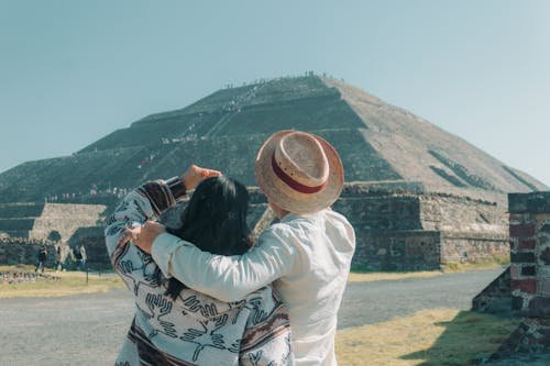 Couple embracing in front of a sun-shaped pyramid, illustrating sun exposure